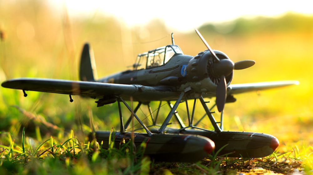 avion de chasse noir et gris sur l’herbe verte pendant la journée
