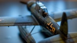 Close-up of a detailed airplane model under construction on a wooden table.