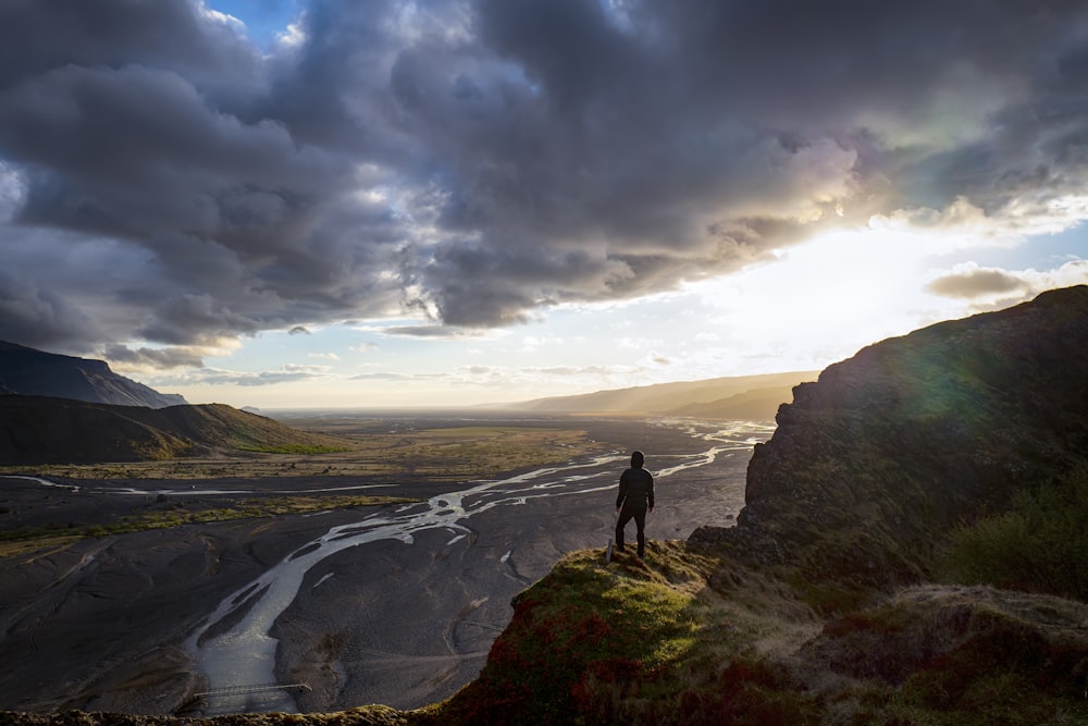 person standing on the edge of the mountain