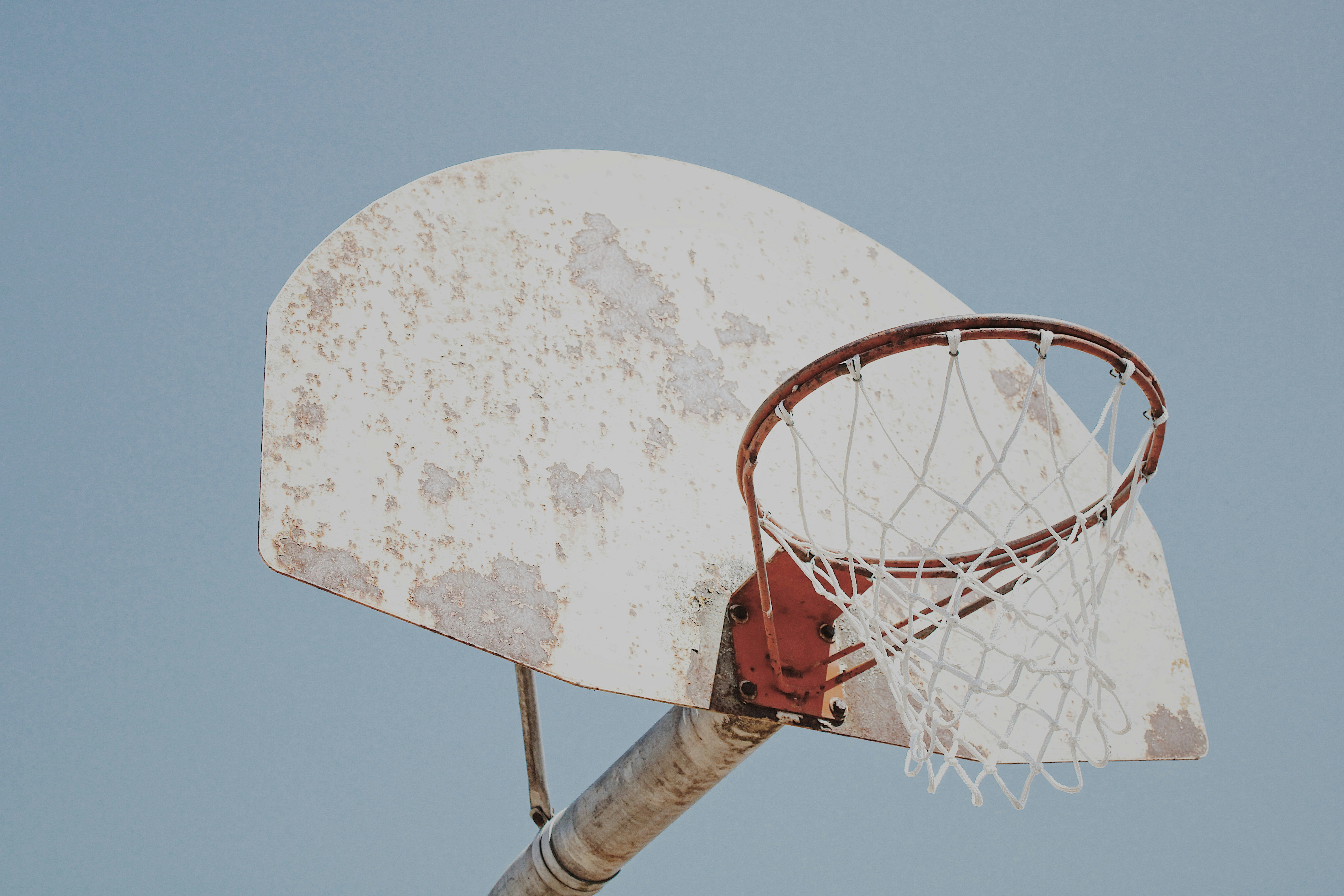 Red basketball hoop under blue sky