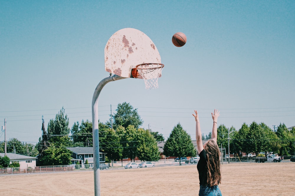 woman in black long sleeve shirt standing on basketball court during daytime