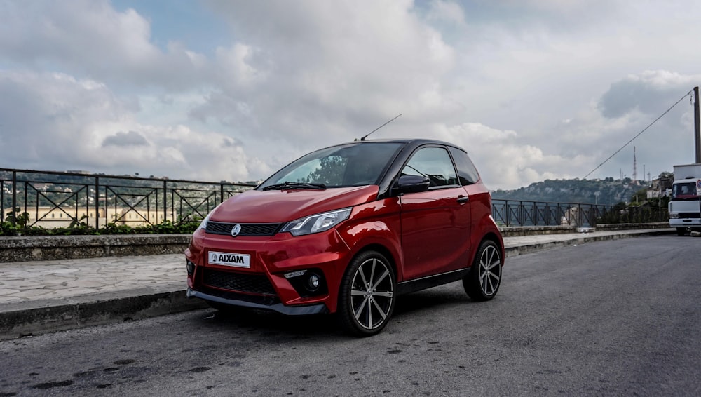 red honda car on gray sand under white cloudy sky during daytime