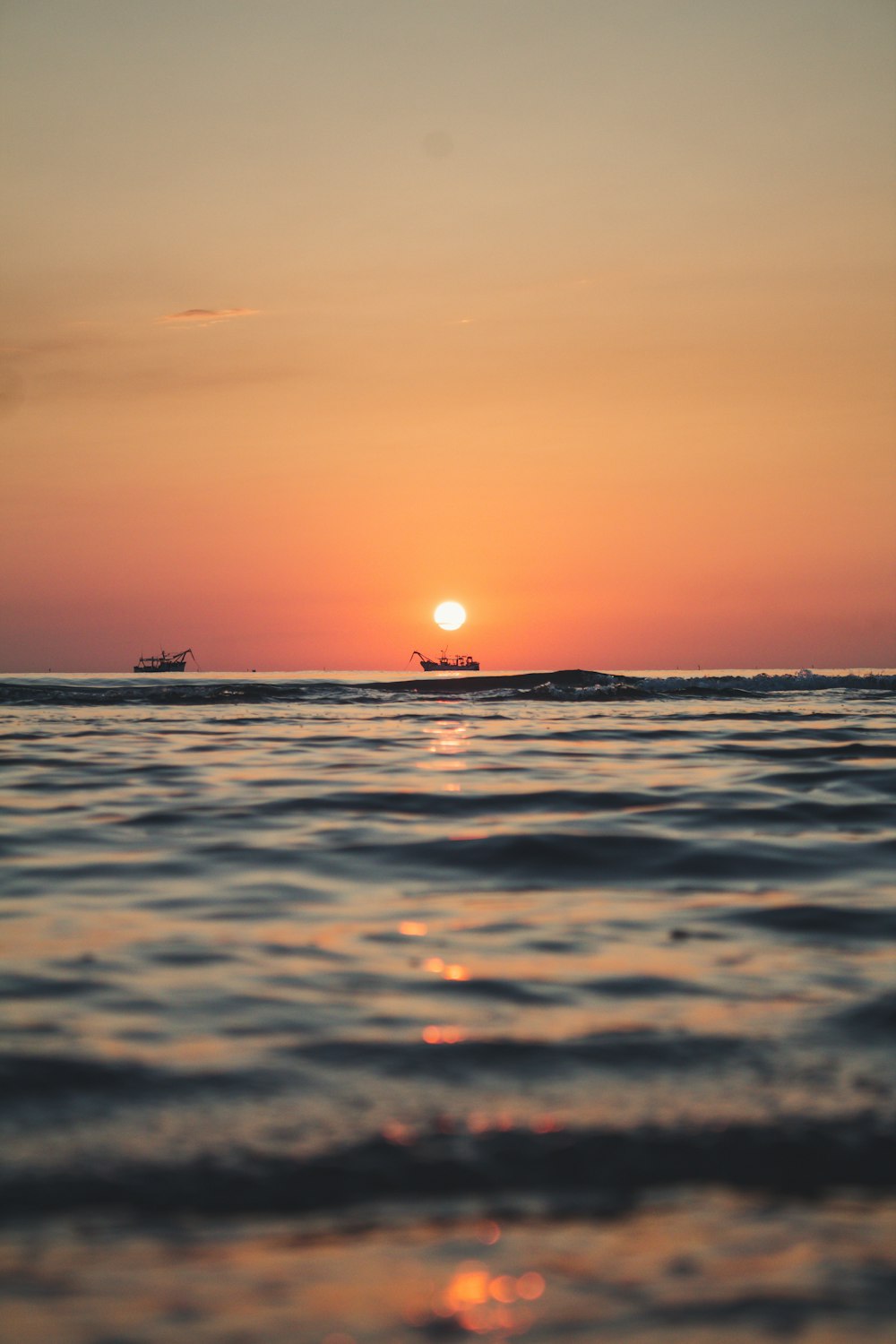 silhouette of boat on sea during sunset