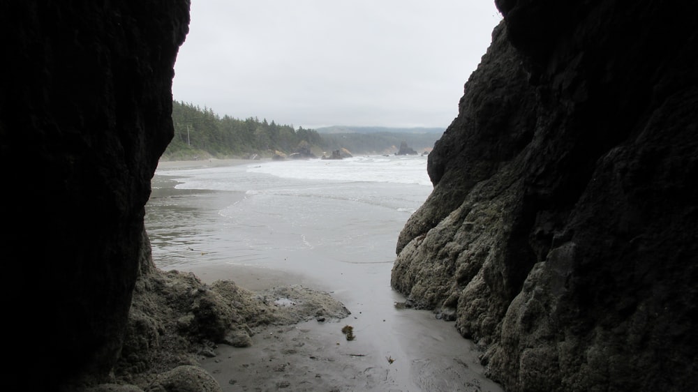 brown rocky mountain beside body of water during daytime