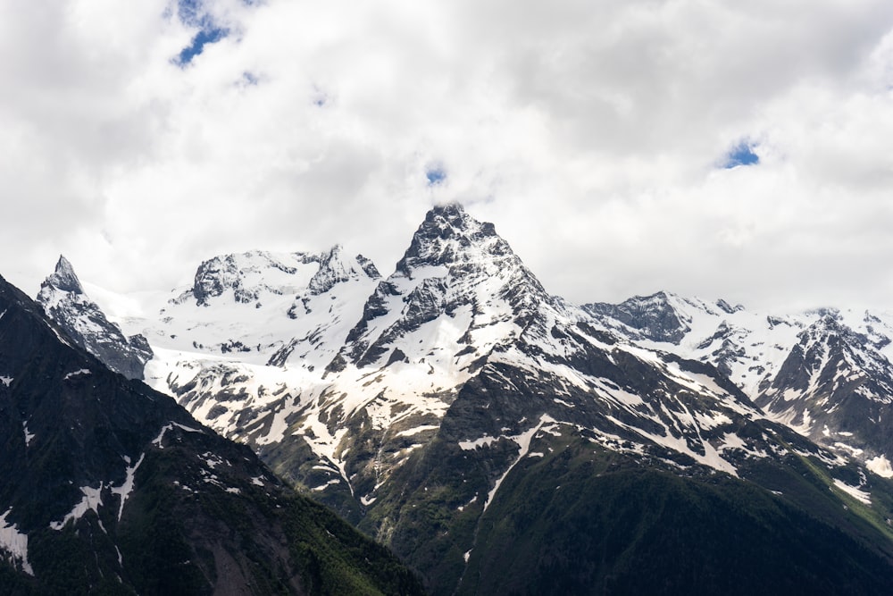 snow covered mountain under cloudy sky during daytime