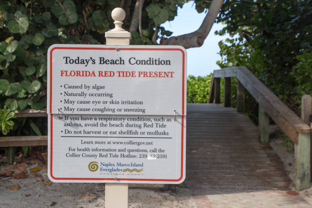 red and white signage on brown wooden fence