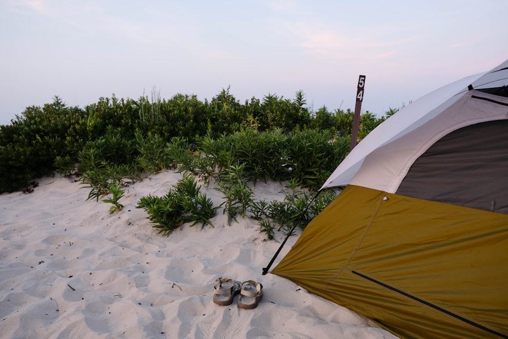 yellow and white tent on brown sand during daytime