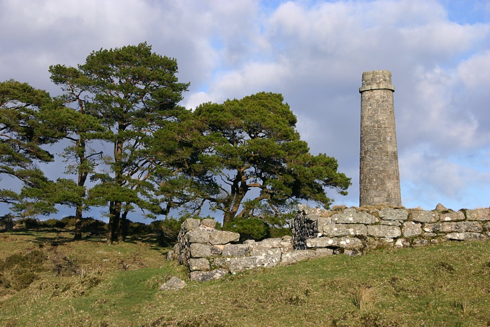 a stone tower sitting on top of a lush green hillside