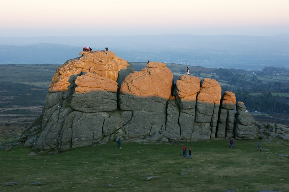 a group of people standing on top of a rock formation