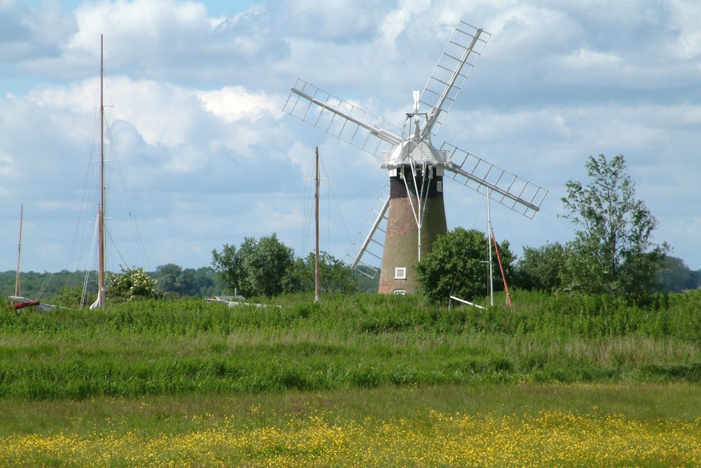 a windmill sits in a field of tall grass