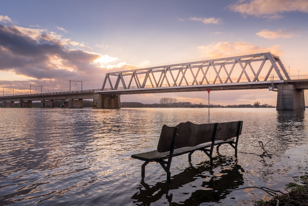 black wooden bench on water