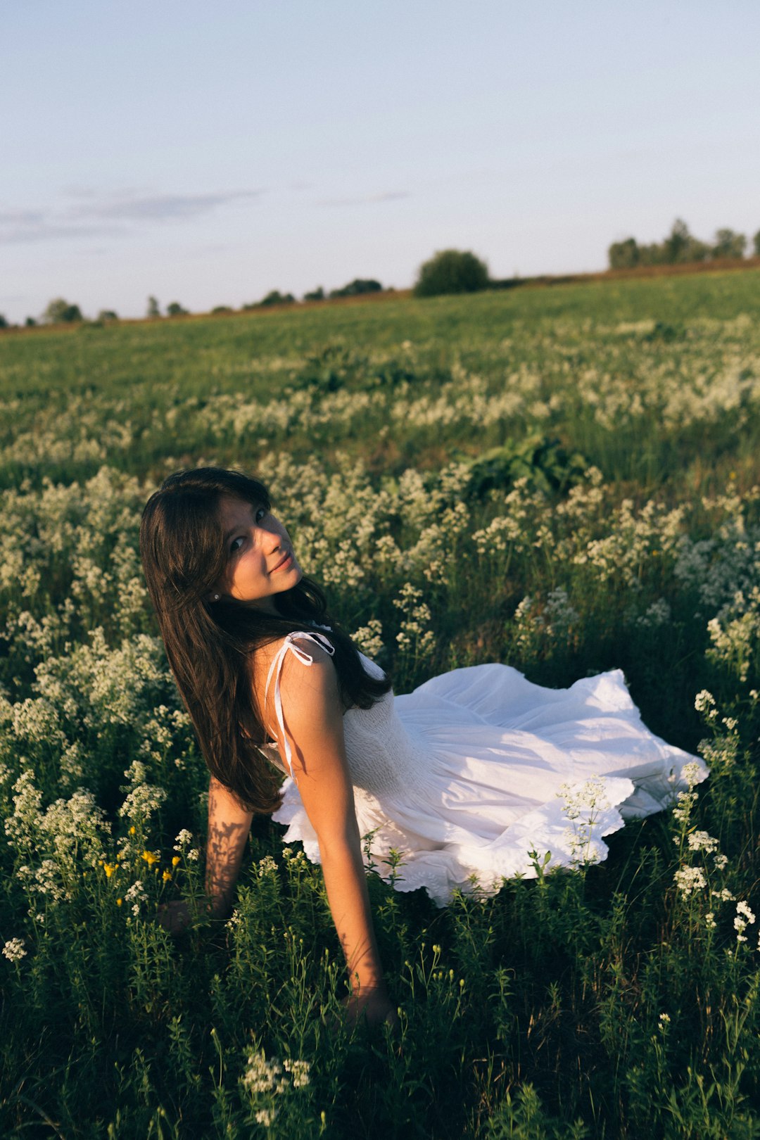 woman in black and white dress sitting on green grass field during daytime