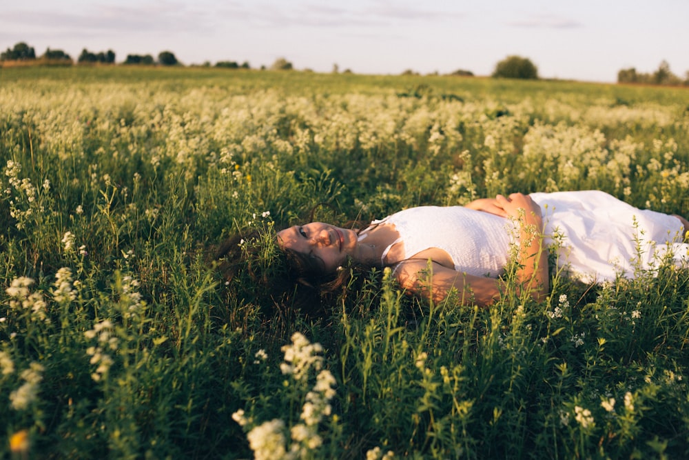 man lying on yellow flower field during daytime