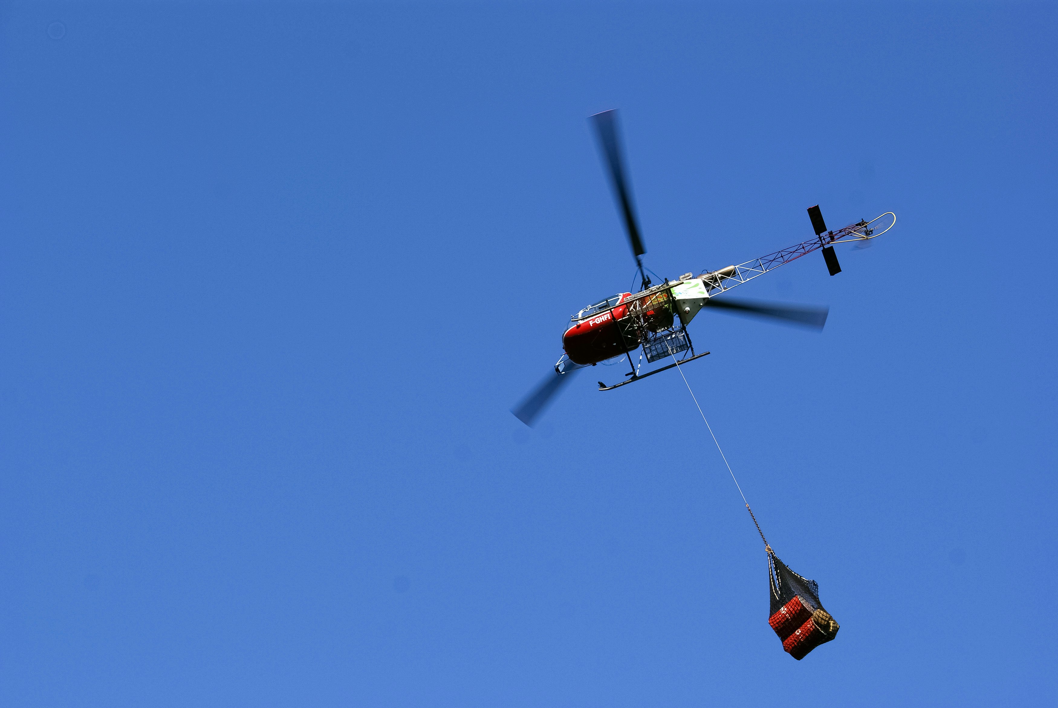 red and black helicopter flying in the sky