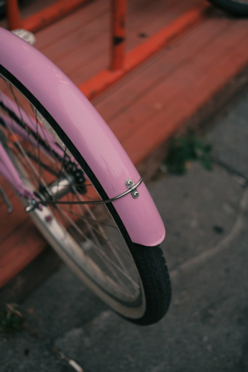 pink bicycle wheel on brown wooden bench