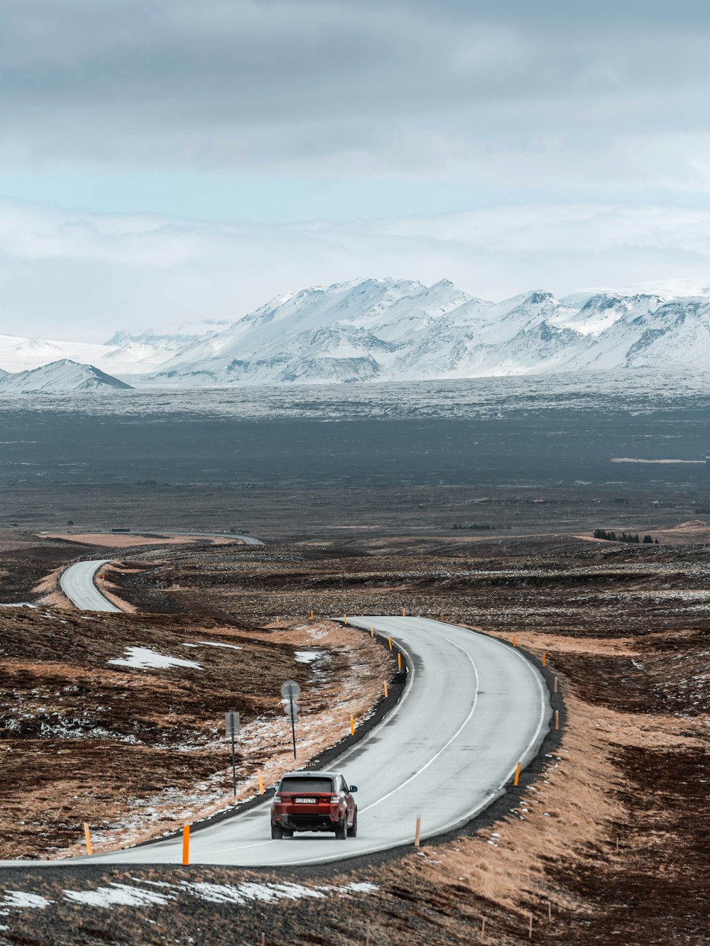 carro branco na estrada perto da montanha coberta de neve durante o dia