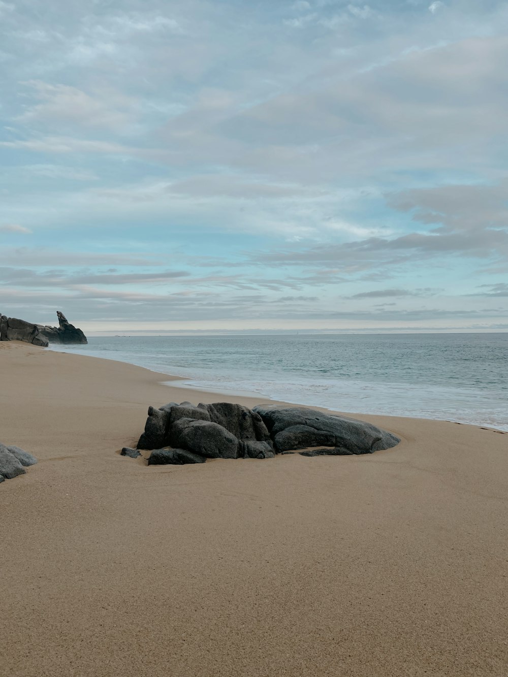 black rock formation on beach during daytime