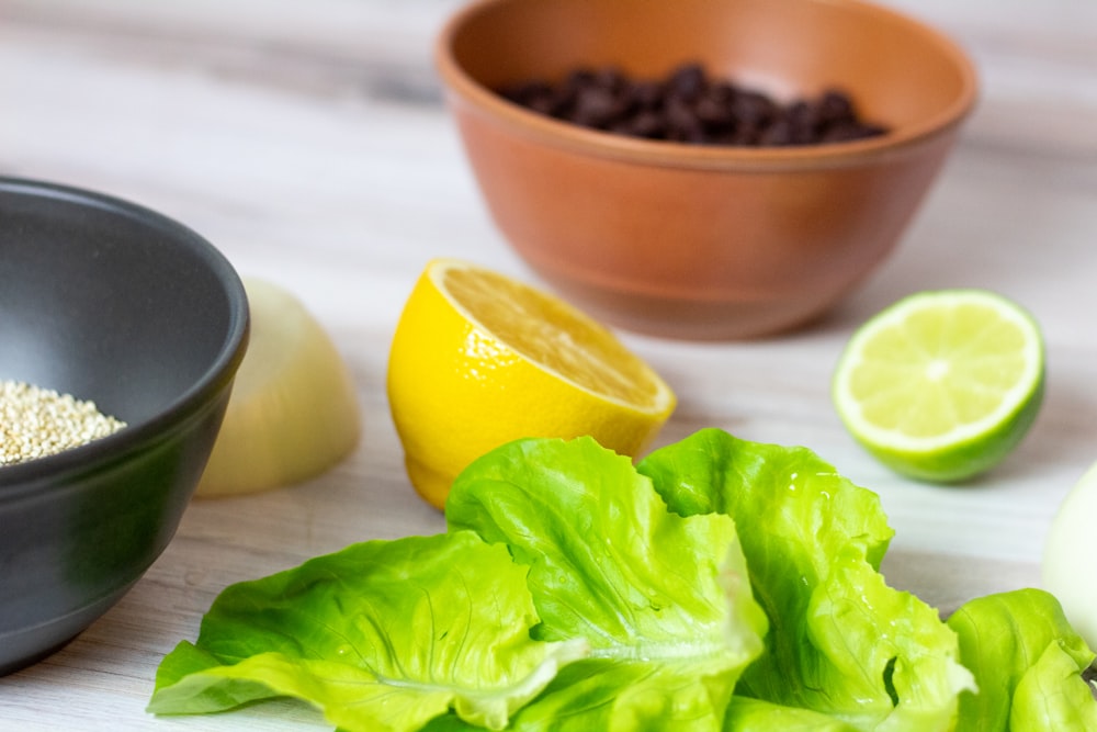 sliced lemon beside brown ceramic bowl with black beans