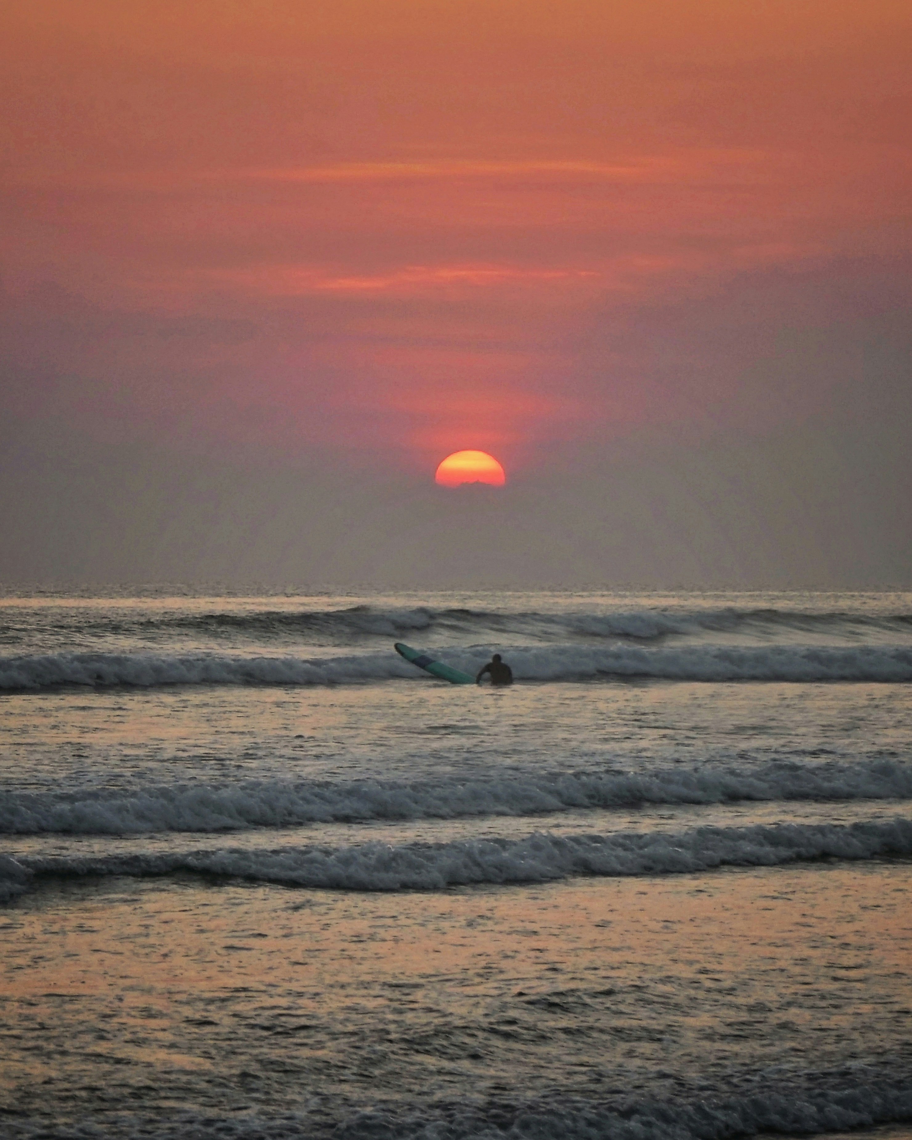 sea waves crashing on shore during sunset