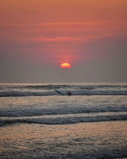 sea waves crashing on shore during sunset
