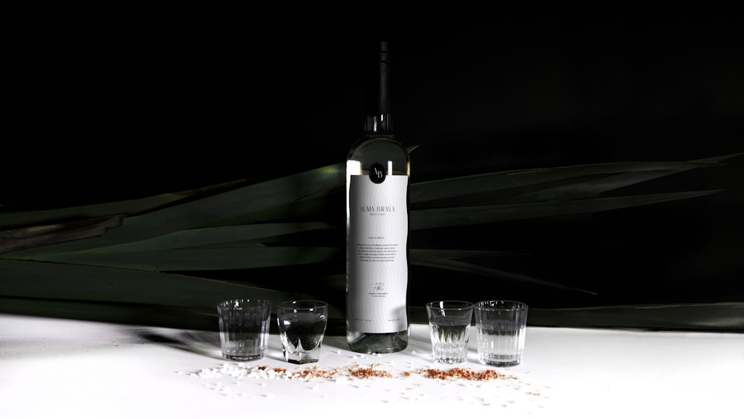 white labeled bottle beside drinking glass, The project began with the need to create a brand for a high-quality mezcal that could compete in a demanding market standing out from its competition with a daring and innovative presence, but without losing the elegance that represents the quality and tradition of the processes with which mezcal is created.<p></figure>It was intended to make an elegant and fine graphic identity, so it was necessary to create a verbal identity in which courage, daring, and pride could be transmitted, reaching the name Alma Brava, which means Brave Soul. 