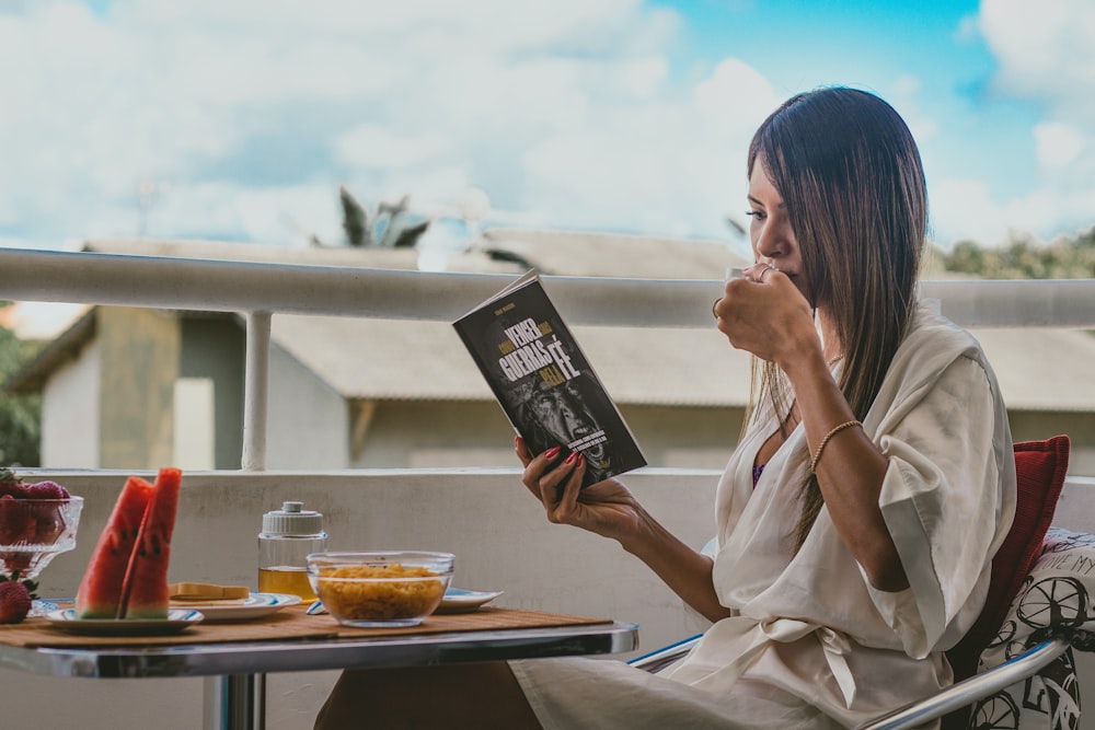 woman in white robe holding black book