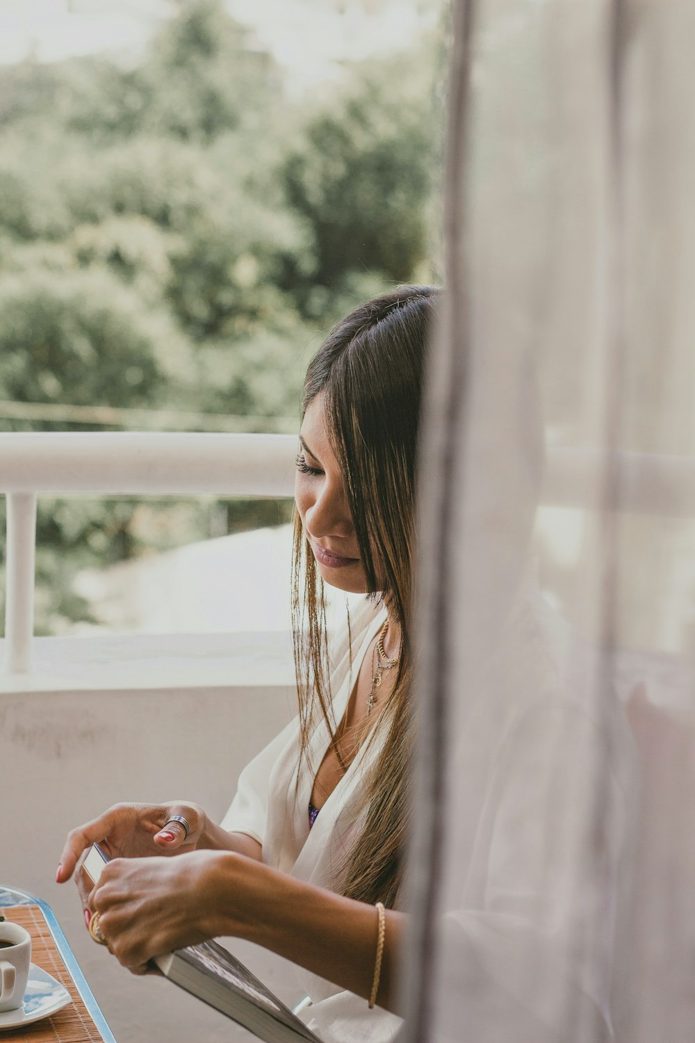 woman in white long sleeve shirt looking at the window