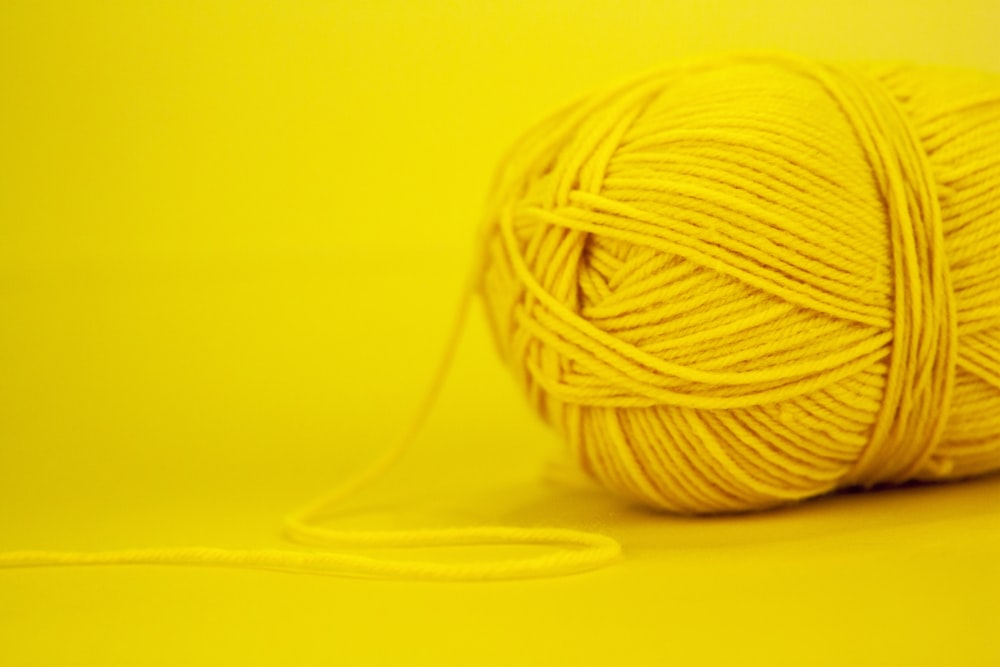 white yarn on yellow surface