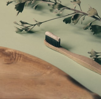brown wooden hair comb on white and green floral textile