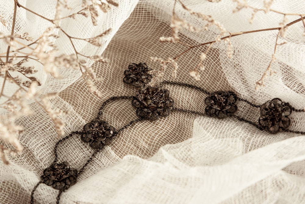 black and brown beaded necklace on white textile