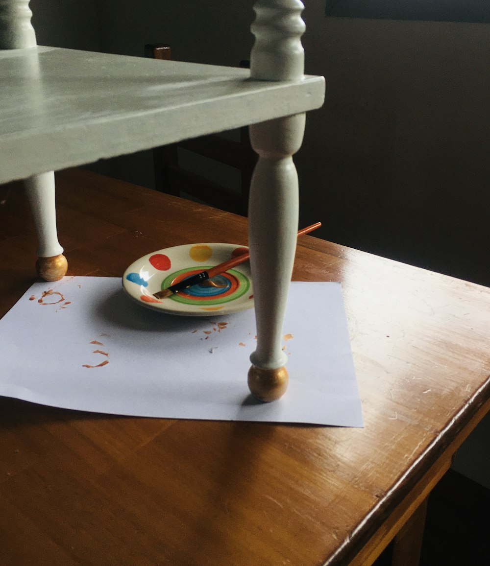 white and yellow ceramic plate on brown wooden table