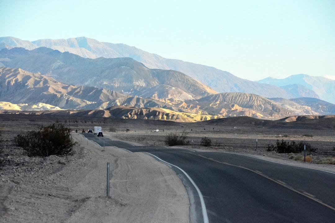 gray concrete road near mountains during daytime