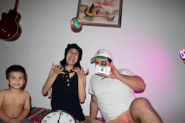 Cozy family scene with children playing while the mother takes a creative studio-quality photo.