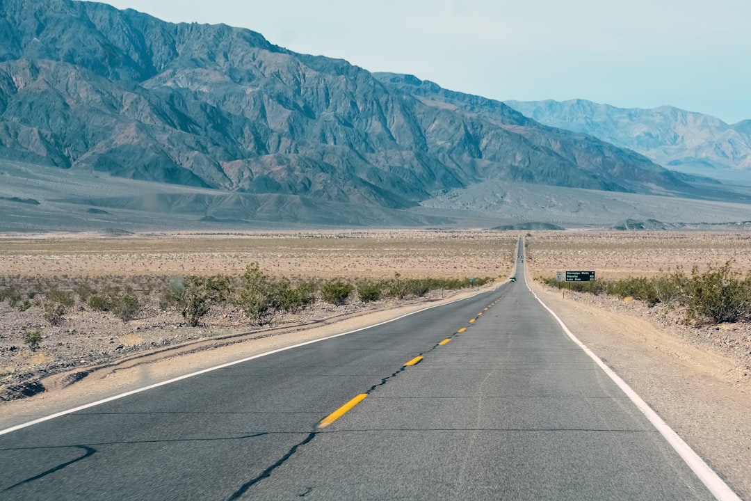 gray concrete road near mountain during daytime