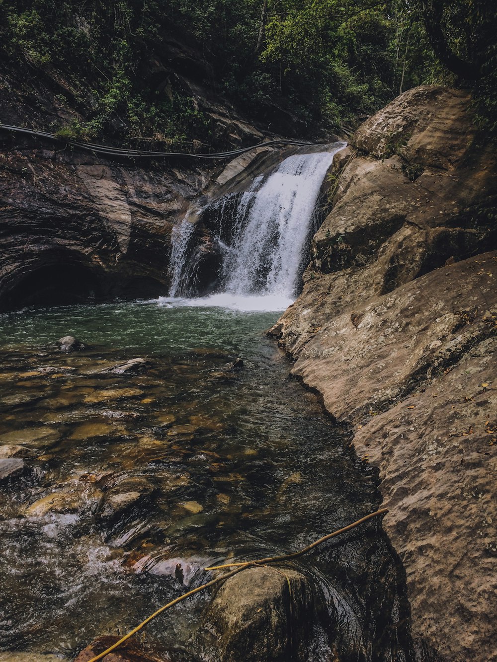 water falls on brown rocky mountain