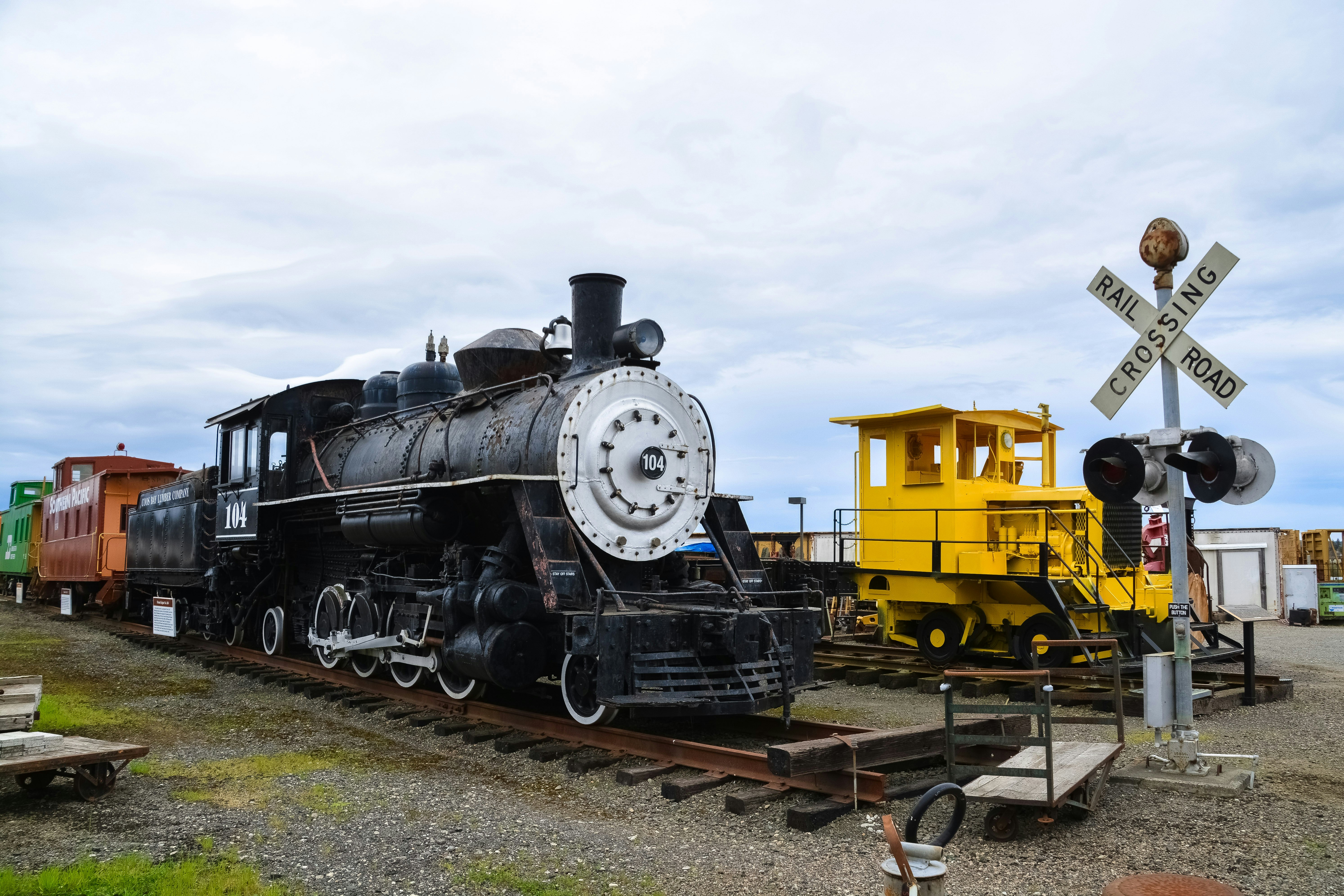 black and yellow train on rail tracks under white clouds during daytime