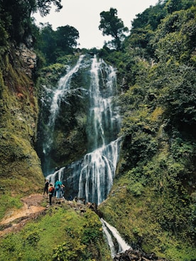 people walking on pathway near waterfalls during daytime