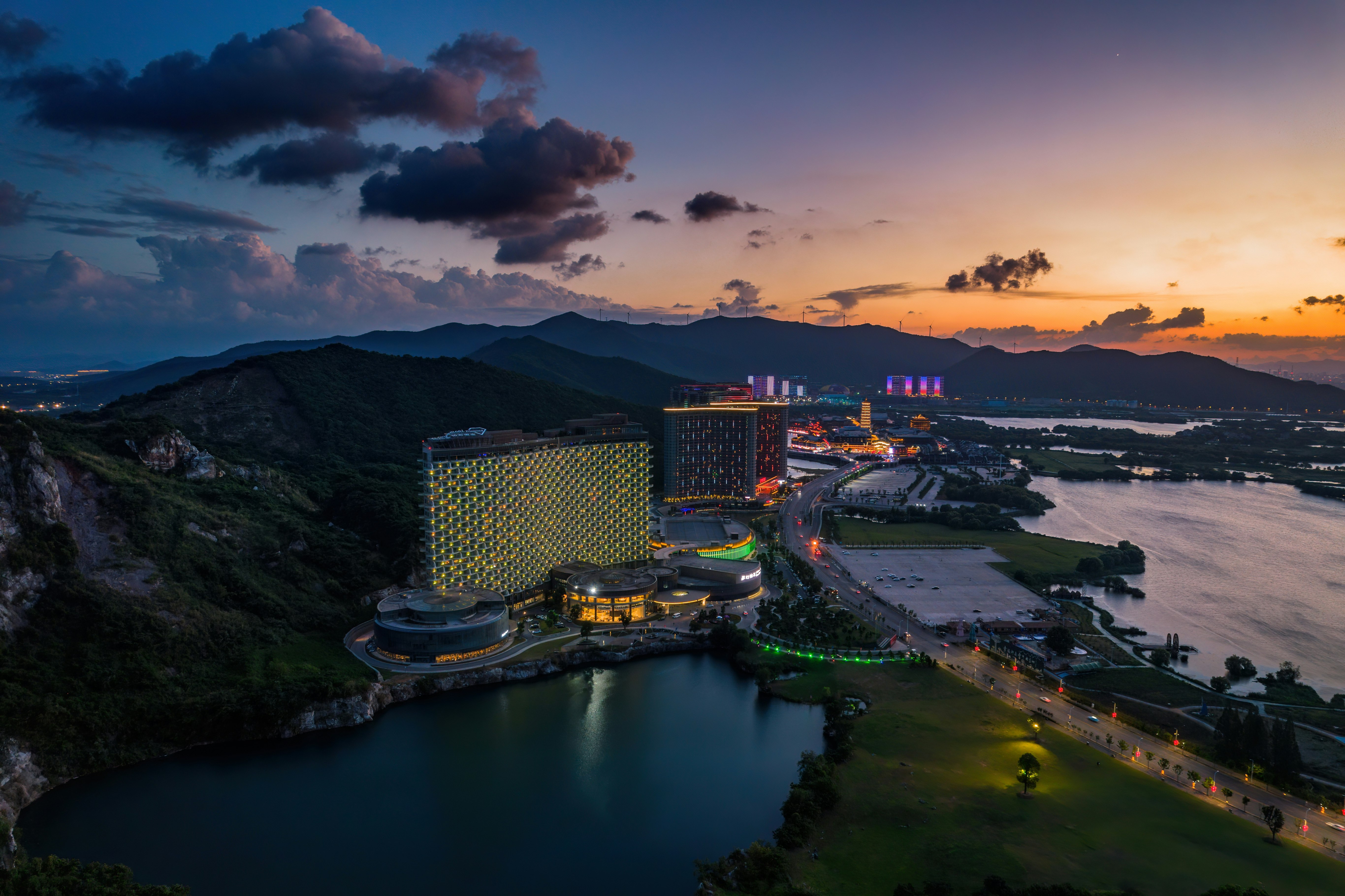 aerial view of city buildings near body of water during sunset