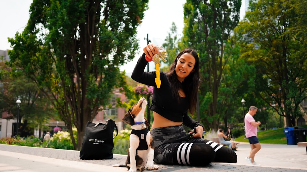 a woman sitting on the ground with a dog