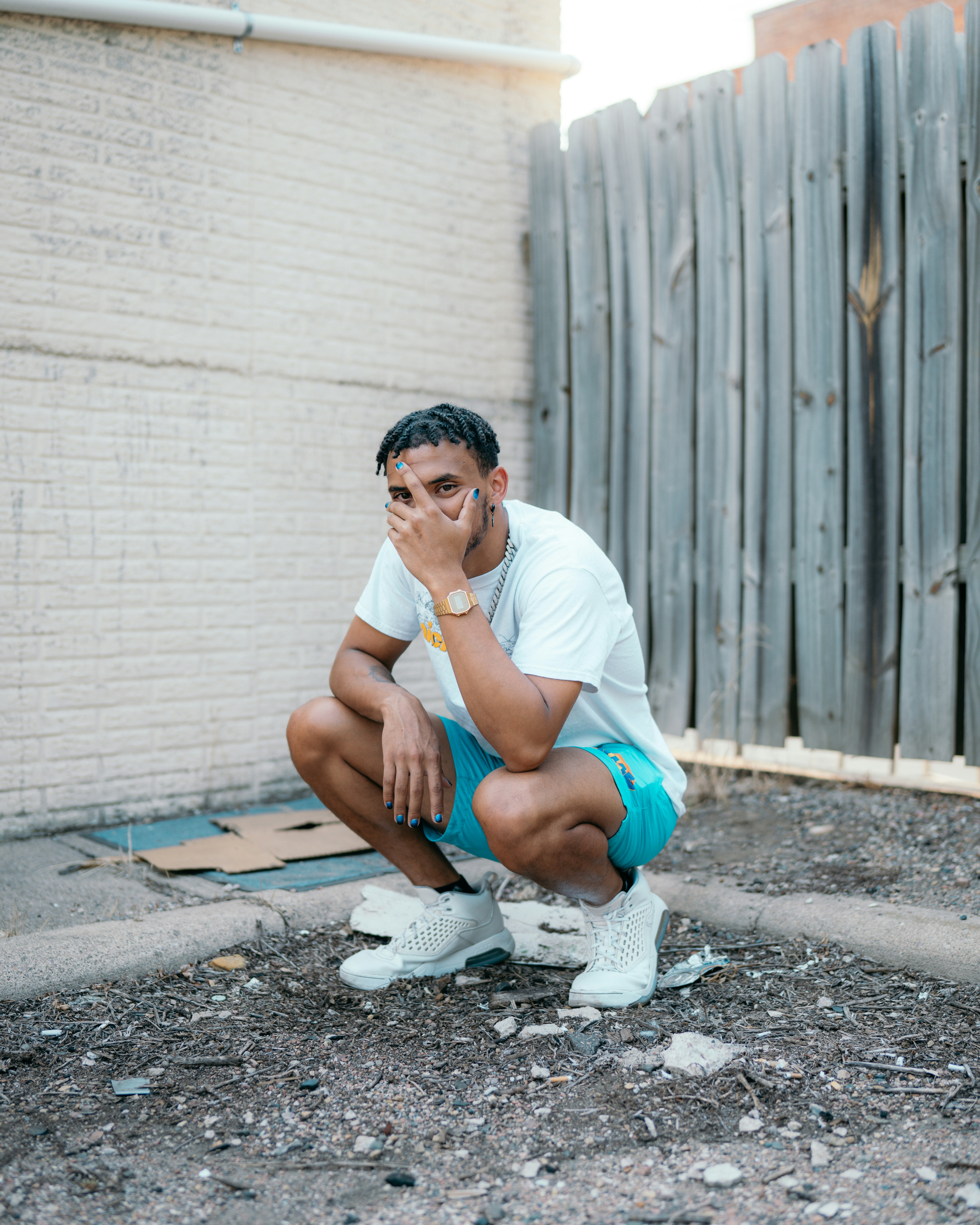 woman in white t-shirt sitting on gray concrete floor