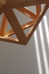 A contemporary geometric sculpture in a bright studio with natural light highlighting its sharp angles.