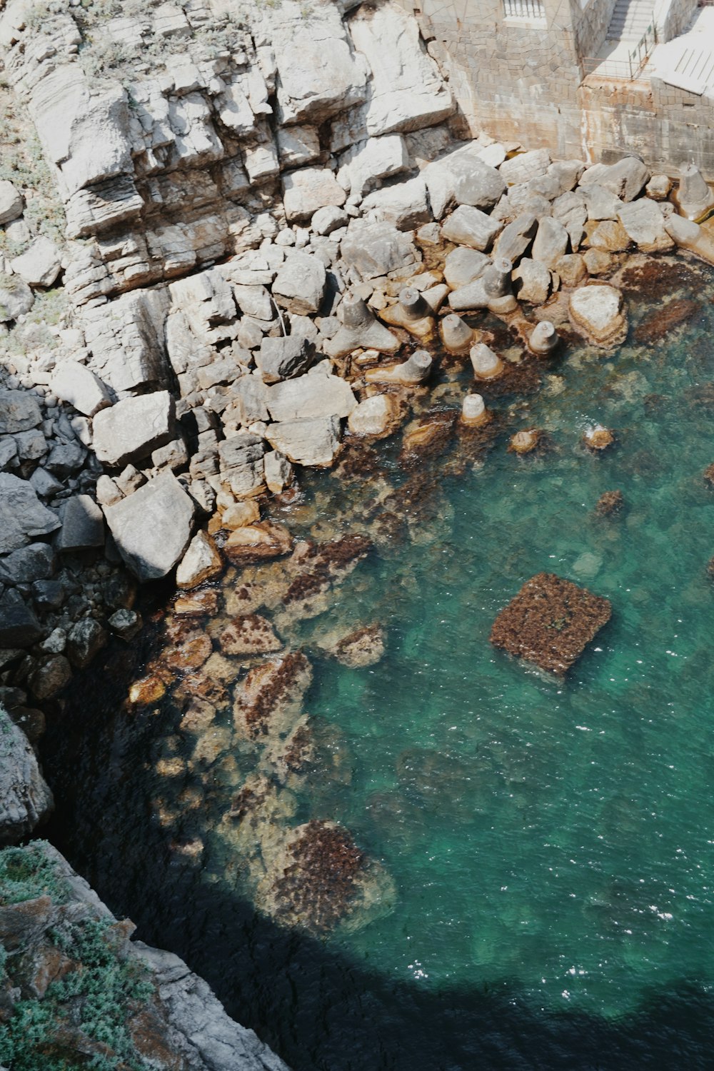 Spiaggia rocciosa grigia con acqua blu