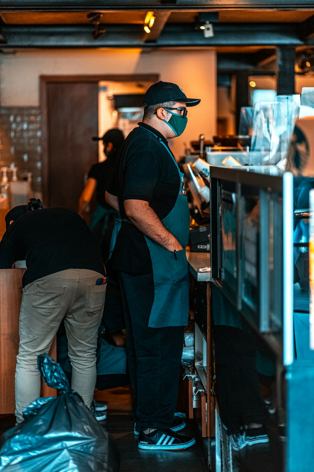 homem na camiseta preta e jeans azul vestindo boné preto