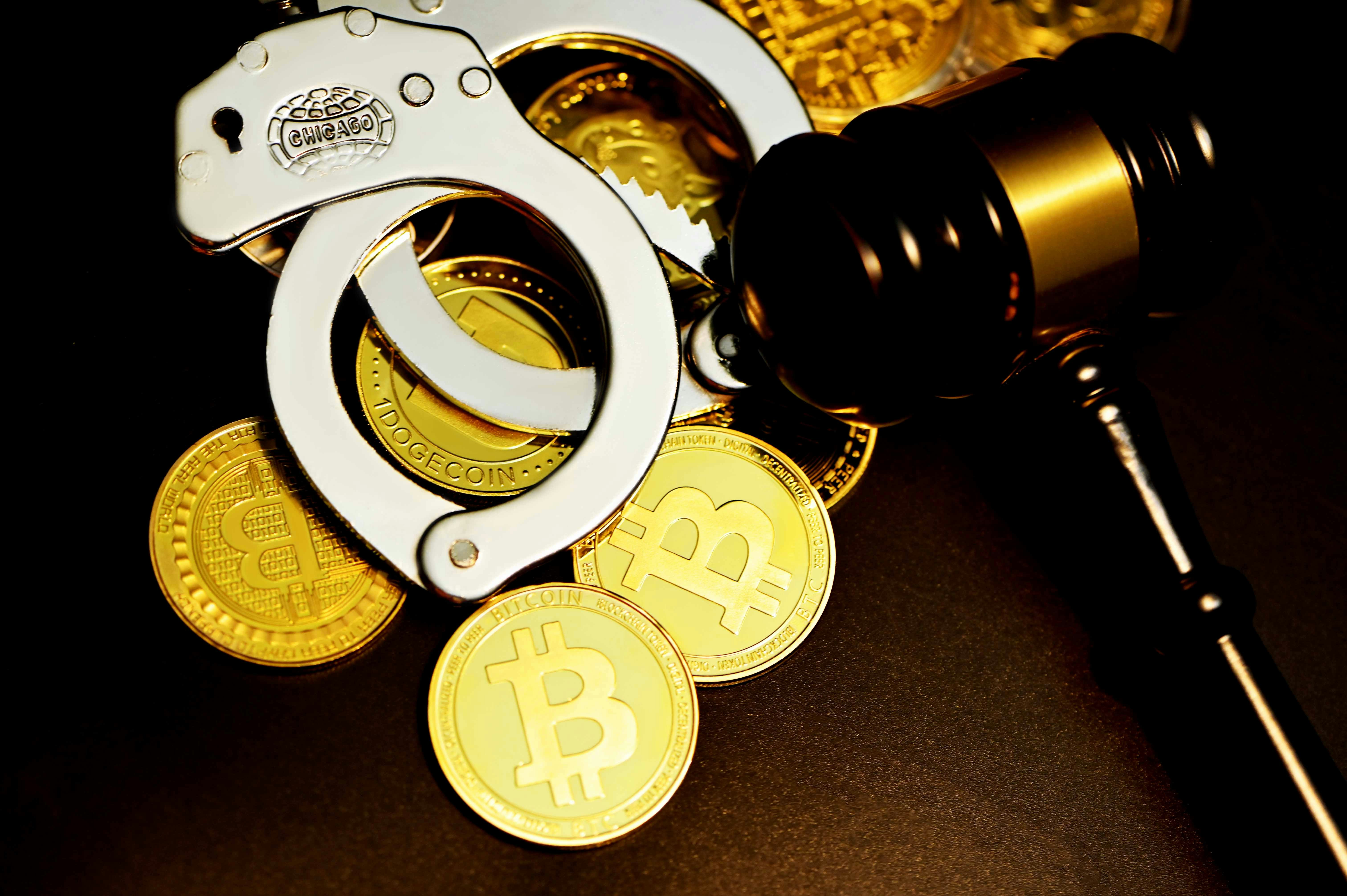 A handcuff is next to the hammer court on top of bitcoin