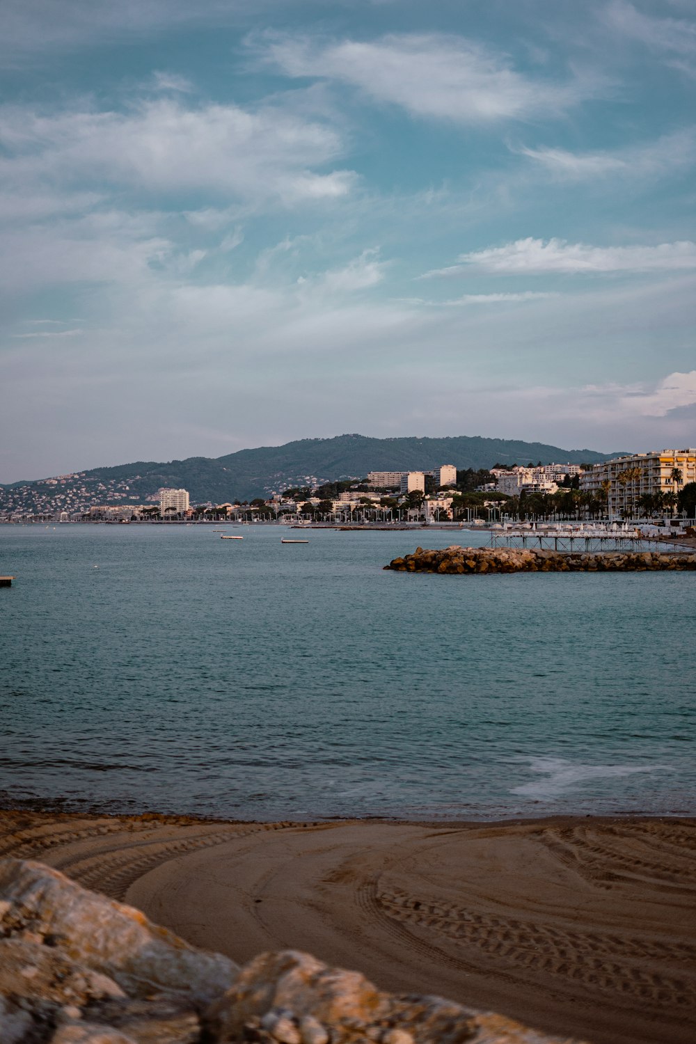 body of water near city buildings under cloudy sky during daytime