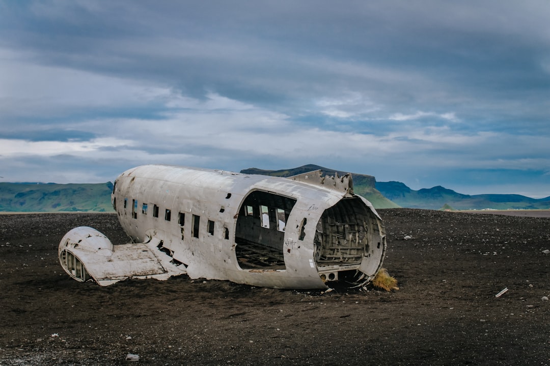 wrecked white airplane on brown field under blue sky during daytime