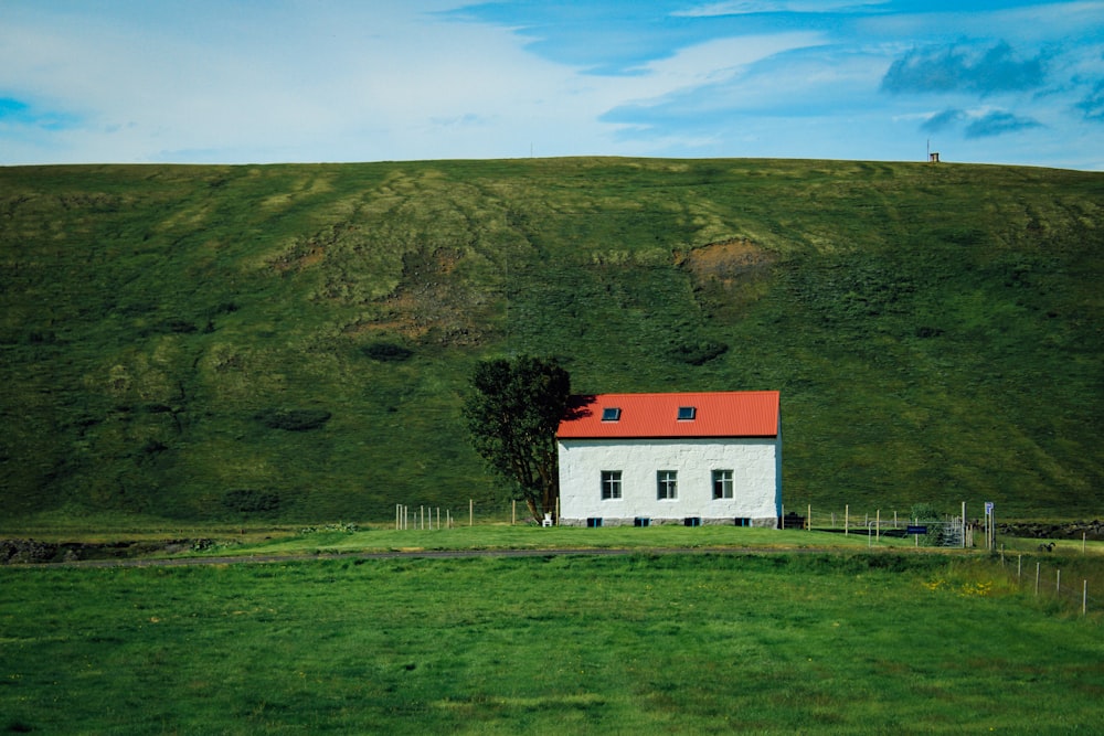 maison blanche et rouge sur le champ d’herbe verte