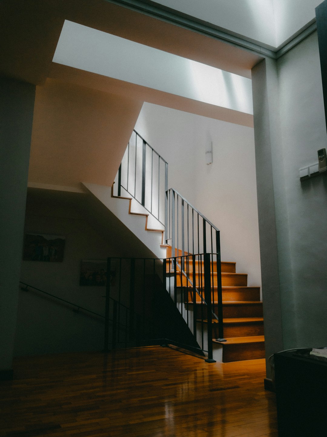 brown wooden staircase on white painted wall