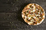 A warm, inviting pizza topped with fresh ingredients on a wooden table.