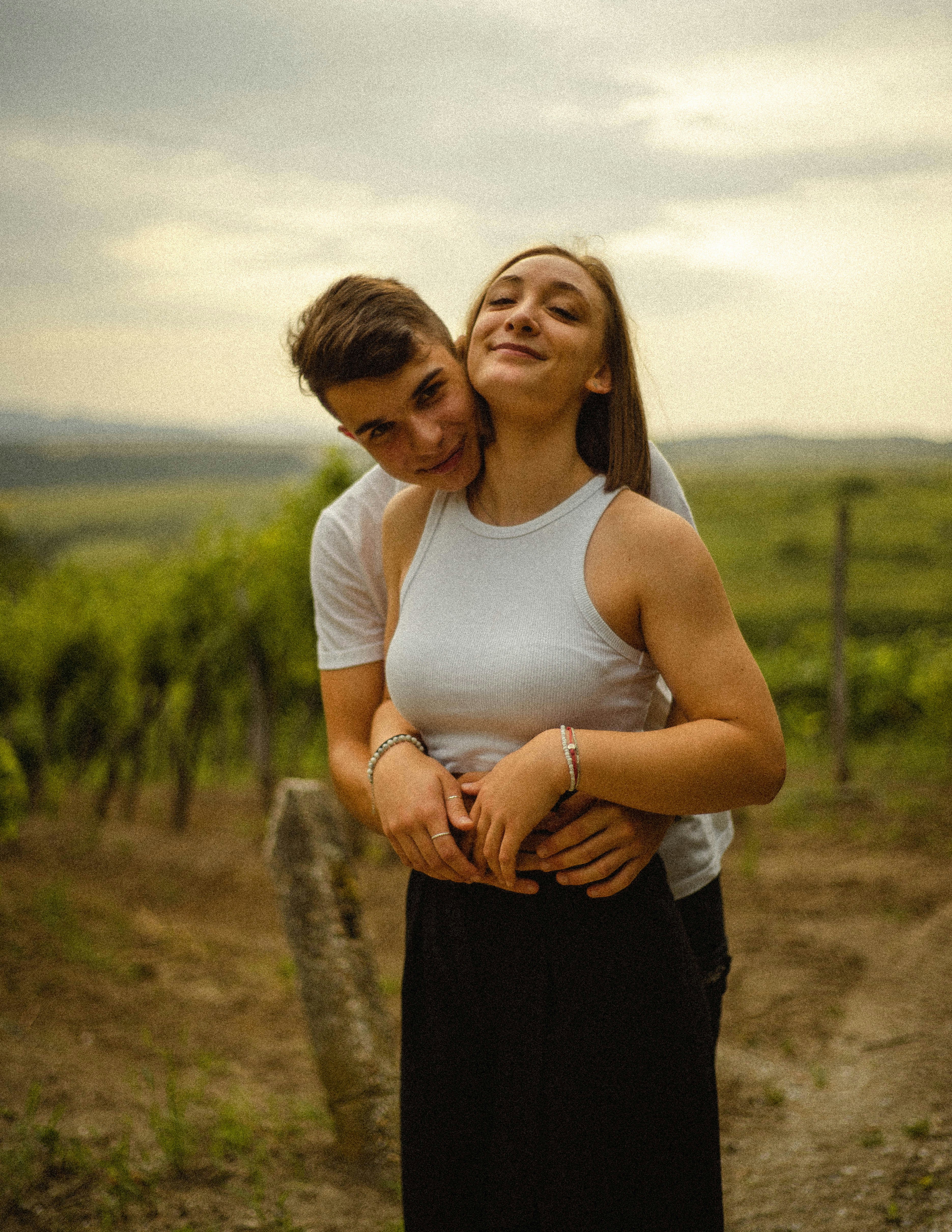woman in white tank top and black pants holding her waist